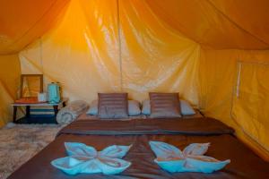 an orange tent with two pillows on a bed at Bansuanariya บ้านสวนอริยะ in Ban Na Yang +11 photos