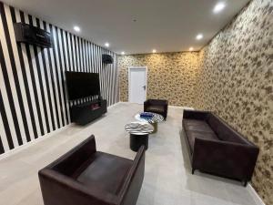 a living room with two leather couches and a piano at Royal Villa in Yoliin Hural