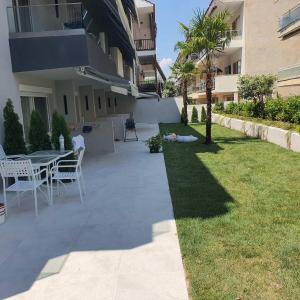 a patio with a table and chairs next to a building at Plagia Relax Hotel in Nea Plagia