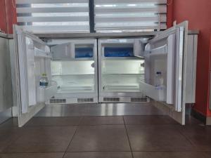an empty refrigerator with its doors open in a room at Villa Sangria in Skala Marion