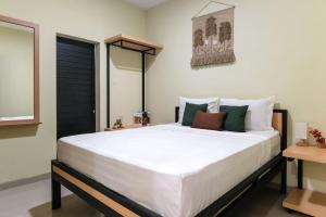 a bedroom with a large bed with white sheets at Rooms at Calma Villa Panorama, Batu Malang in Batu
