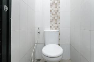a bathroom with a white toilet with a hose at Rooms at Calma Villa Panorama, Batu Malang in Batu