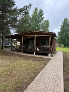 a small wooden building in a park with a sidewalk at Razna Lake House in Astici