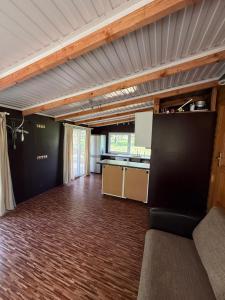 a living room with a couch and a kitchen at Razna Lake House in Astici +7 photos
