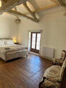 a bedroom with a bed and a chair and a window at La Maison des Sources in Édon