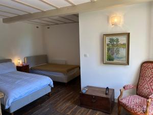 a hotel room with two beds and a chair at La Maison des Sources in Édon