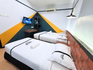 two beds in a room with a wall at Seeds Hotel Kuala Selangor in Kuala Selangor