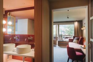 a kitchen and living room with a table and chairs at Hotel Berghof in Lech am Arlberg +257 photos