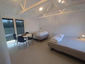 a room with two beds and a table and chairs at Byhus Vejle in Vejle