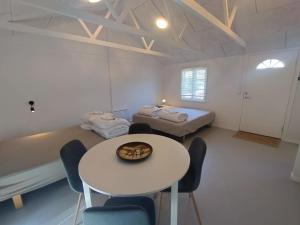 a room with two beds and a table and chairs at Byhus Vejle in Vejle
