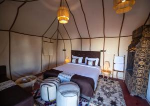 a bedroom with a large bed in a tent at Sahara Crown Luxury Camp in Merzouga