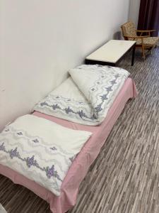 a bed with two pillows and a table in a room at Internát Tvrdošín in Lazy pod Makytou