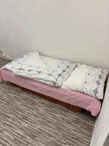 an unmade bed in a room with a pink mattress at Internát Tvrdošín in Lazy pod Makytou