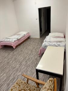 a room with two beds and a table and a chair at Internát Tvrdošín in Lazy pod Makytou