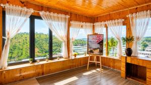 a living room with windows and a fireplace at LaLa Hill in Ấp Kim Thạch