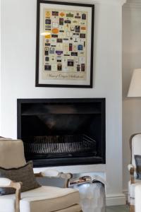 a fireplace in a living room with a picture above it at Winelands Golf Lodges 28 in Stellenbosch