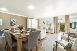a dining room and living room with a table and chairs at Winelands Golf Lodges 28 in Stellenbosch