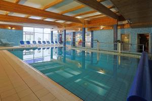 a large swimming pool with chairs in a building at Hotel Lidia - część Economy in Darłowo