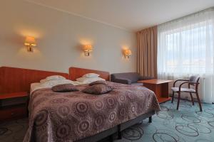 a hotel room with a bed with pillows on it at Hotel Lidia - część Economy in Darłowo