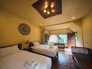 a hotel room with two beds and a window at The Moon Rabbit Resort Pai in Pai +31 photos