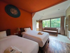a hotel room with two beds and a window at The Moon Rabbit Resort Pai in Pai