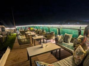 a restaurant with tables and chairs on a deck at night at Red Fox by Lemon Tree Hotels, Alwar in Alwar