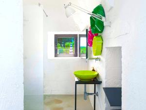 a bathroom with a green bowl on a stool at Cocotrullo in Ostuni