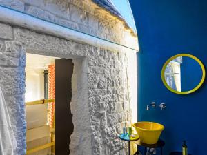 a bathroom with a stone wall and a yellow sink at Cocotrullo in Ostuni +53 photos