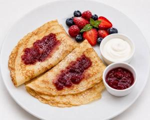 a white plate with pancakes and berries and dip at Hotel Victory Home - 10min Lotnisko Chopina, 15min to Zachodni, 5min to Progresja in Warsaw
