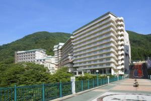 two tall buildings in front of a mountain at Ooedo Onsen Monogatari Hotel Kinugawa Gyoen in Nikko