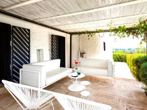 a patio with two white chairs and a table at Cocotrullo in Ostuni