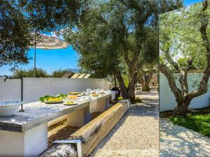 a table with food on it next to a fence with trees at Cocotrullo in Ostuni