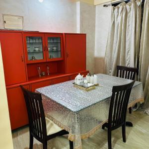 a dining room with a table and red cabinets at StayLuxe Rooms & Apartments Near BKC, Chembur in Mumbai +22 photos