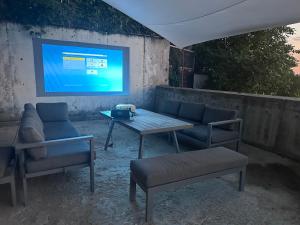 a table and two chairs and a television on a wall at Altura House in Almaty