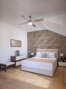 a bedroom with a white bed and a brick wall at Silvia's Haus in Neos Marmaras