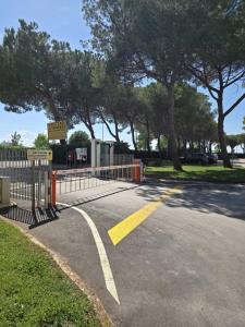 a gate on a road with a sign and trees at Residence di Raul in Porto Recanati