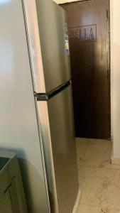 a stainless steel refrigerator in a kitchen with a door at Biu Bela abartment hotel 2 in El Alamein +15 photos