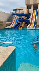 a man swimming in a swimming pool in a water park at Biu Bela abartment hotel 2 in El Alamein