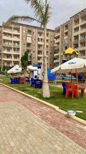 a group of tables with umbrellas in front of a building at Biu Bela abartment hotel 2 in El Alamein
