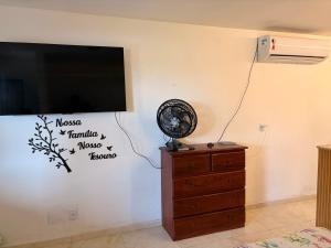 a room with a tv and a fan on a wall at Resort felicidade anexos in Extremóz +5 photos
