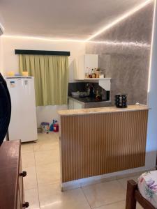 a kitchen with a counter and a refrigerator at Resort felicidade anexos in Extremóz