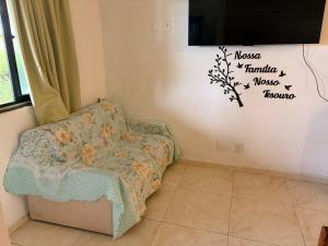a living room with a chair and a tv at Resort felicidade anexos in Extremóz