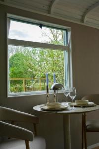 a table with two wine glasses and a window at Bed & Bloemen in Niebert