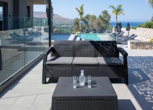 a patio with a couch and a table with glasses on it at Villa Manel in Georgioupoli +91 photos
