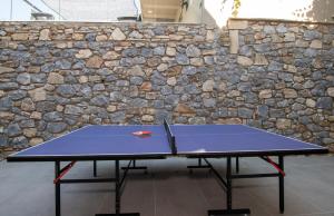 a ping pong table in front of a stone wall at Villa Manel in Georgioupoli