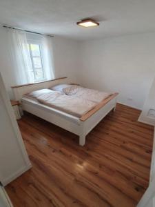 a bed in a room with a wooden floor at Rheinhessen Auszeit in Wendelsheim