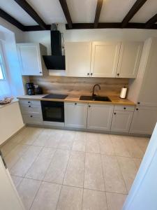 a kitchen with white cabinets and a sink at Rheinhessen Auszeit in Wendelsheim +1 photo