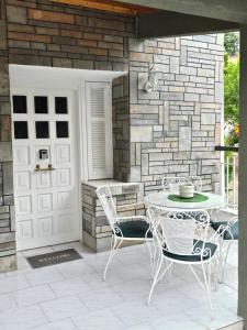 a patio with a table and chairs and a door at Anna-Maria in Nea Kallikrateia