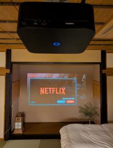 a netflix sign on the wall of a bedroom at 和の貸切宿yanagiya in Daisen