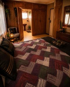 a bedroom with a large bed with a quilt on it at Bushman Kraal Backpackers in Soweto